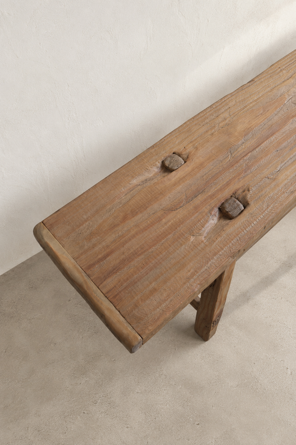 The Longhouse Bench by Juniper & Bros., a long, narrow wooden bench with rustic architectural lines.
