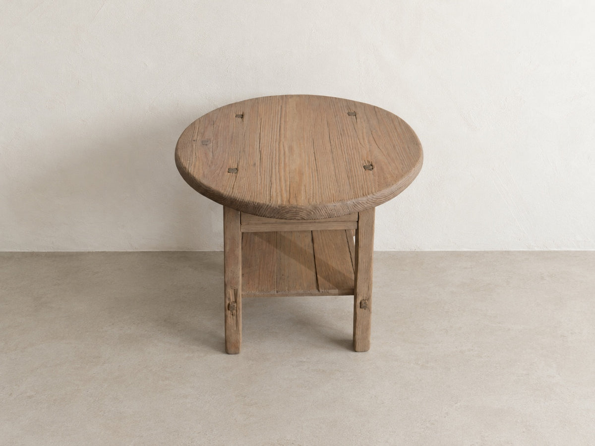     Front elevated view of The Cooper Table with round top, functional drawer, and lower storage shelf