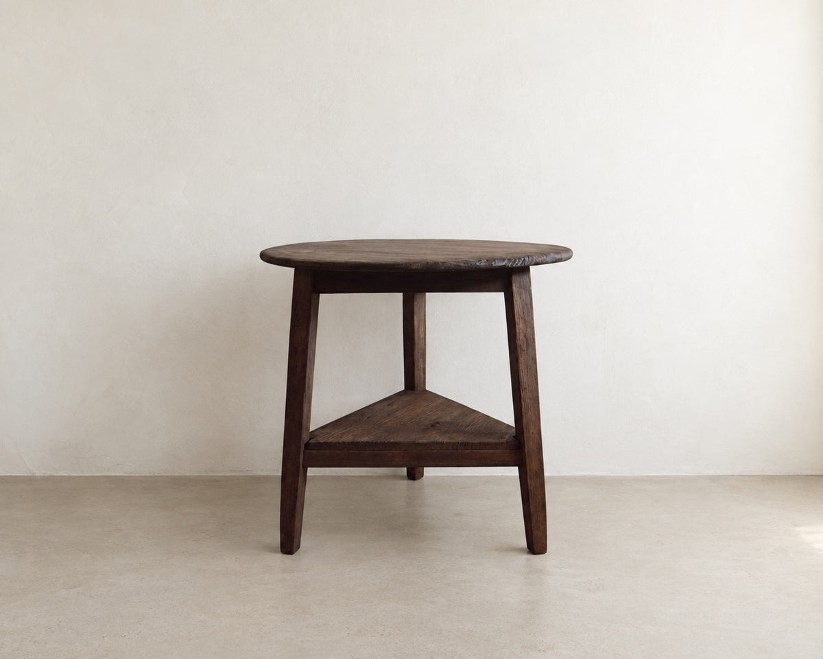 Front view of The Cricket Table, a handmade round accent table with three legs and a triangular lower shelf