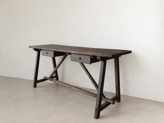 Angled view of The Trestle Console showing two drawers, trestle legs, and diagonal braces